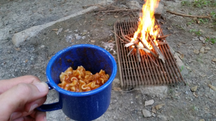 Lasagna in my coffee mug, and my newly-started fire that I hoped would ward off a few insects (it did not).